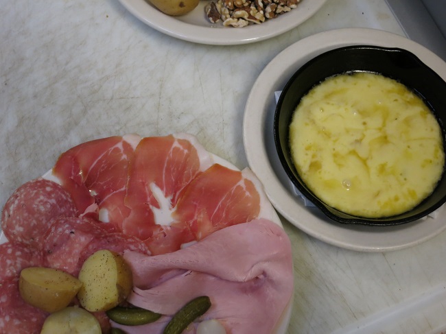 Raclette:  broiled mountain cheese served with your choice of either traditional cold cuts and pickles or with apples, pears, walnut, both with steamed yellow potatoes.
