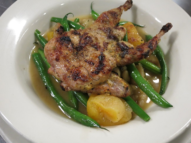 Grilled mustard and sage marinated quail served on flageolet beans, green beans and dried apricot jus.