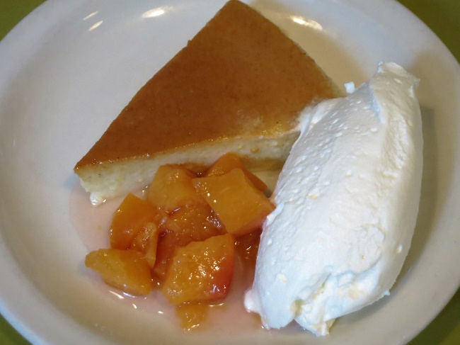 U Pastizza, Corsican pudding cake scented with lemon and vanilla, served with peach compote and whipped cream